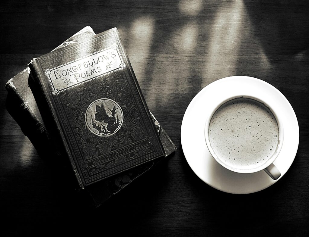 A captivating vintage still life of a coffee cup and Longfellow's poems book